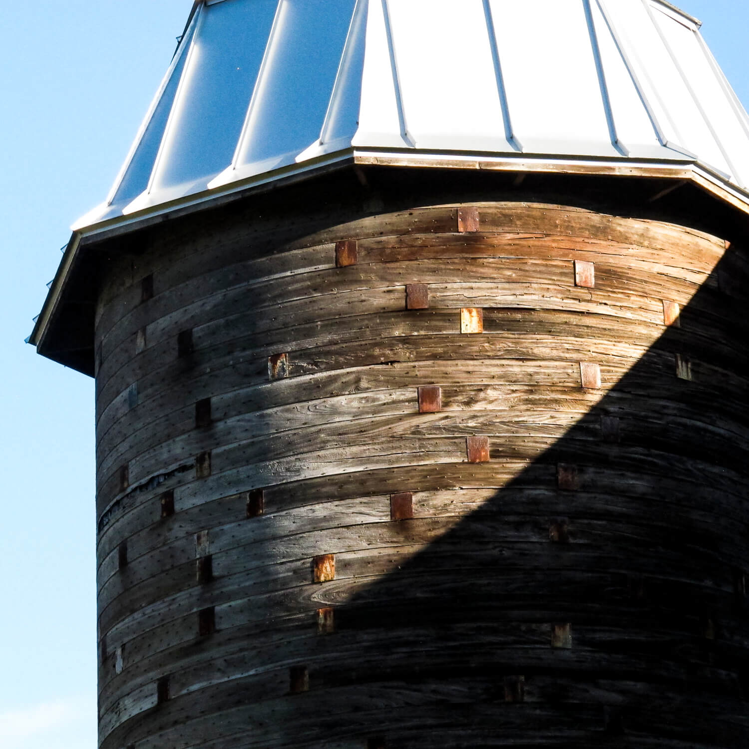 A close up view of a grain silo with wooden slat siding