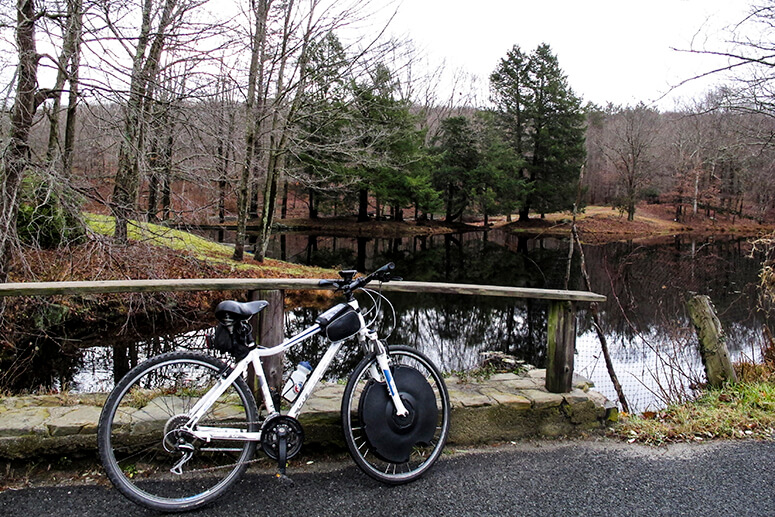 a bike rests on a wooden fence with a pond in the background on this how to use page