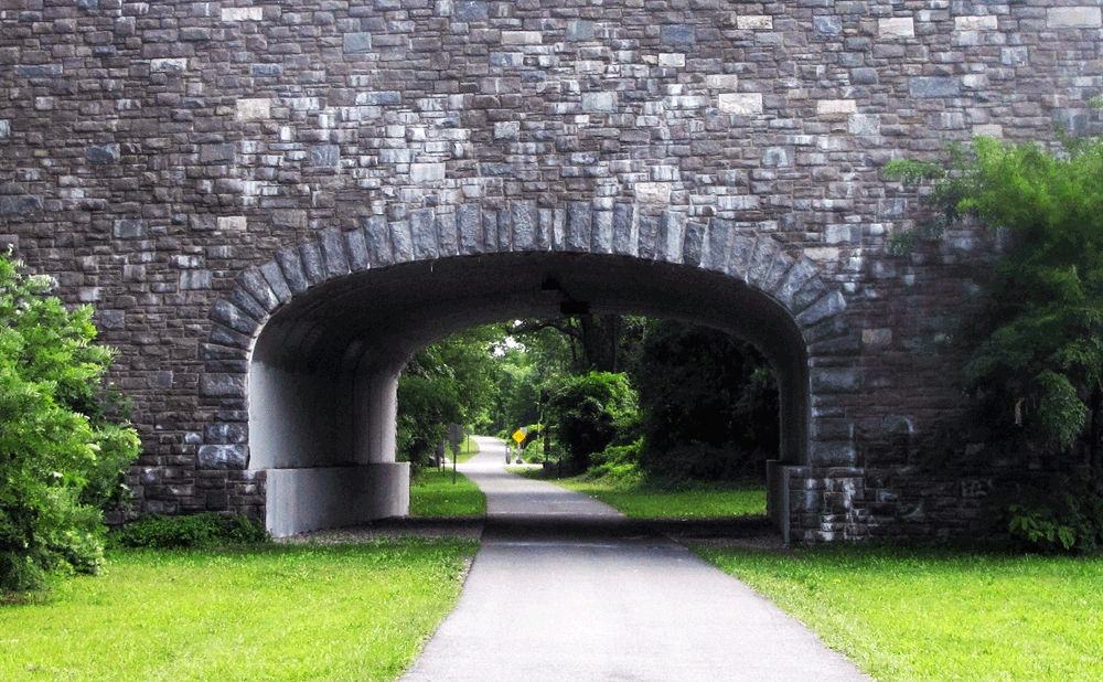 A large stone underpass along a bike path