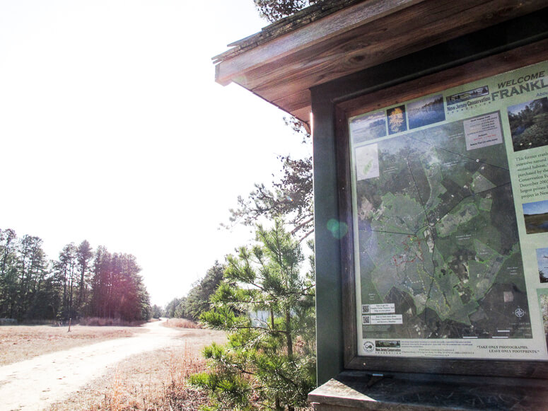 a trailhead kiosk near a sandy road