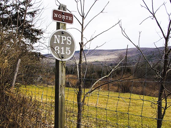 an old highway sign near a valley