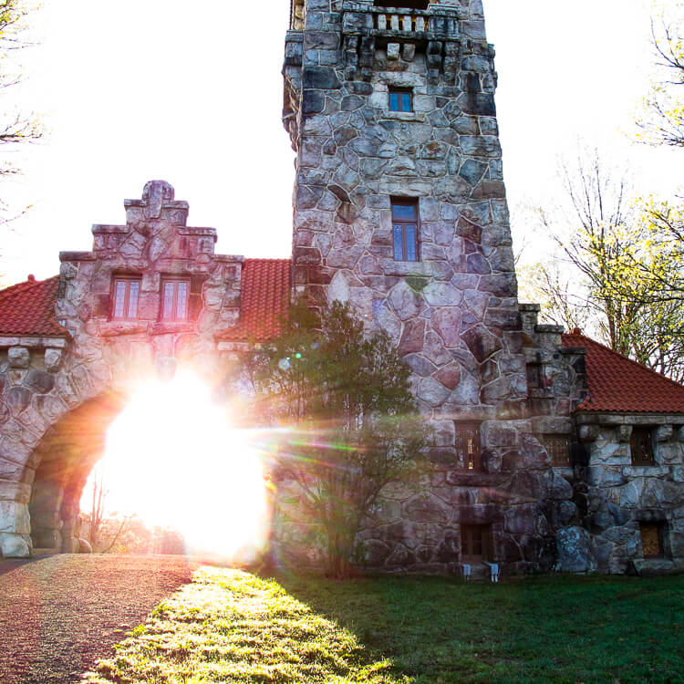 Sunrise streams through a large stone gatehouse -- the Testimonial Gate -- at Mohonk Preserve in New Paltz, New York.